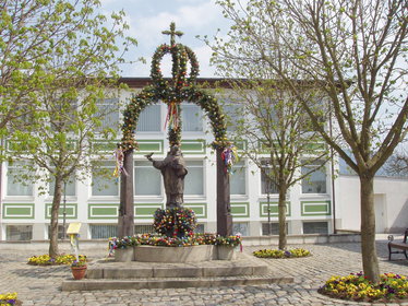 Blick auf den geschmückten Osterbrunnen am Platz vor dem Neuen Rathaus von Bad Kötzting