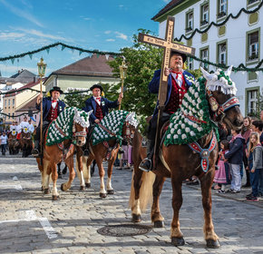 Prächtig geschmückte Pferde und Reiter, angeführt vom Kreuzträger, ziehen betend von Bad Kötzting nach Steinbühl.