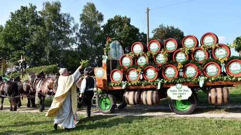 Der Priester bei der Segnung eines großen Brauereigespannes mit vielen Bierfässern Feldgottesdienst im Rahmen des "Bad Kötztinger Rosstag"