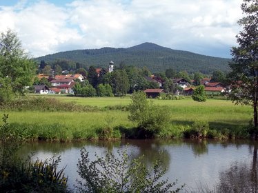 Blick über einen Fluss zum Ort Grafenwiesen im Hintergrund sieht man einen Berg