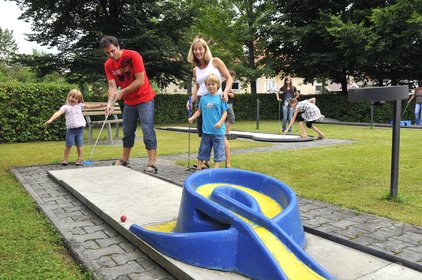 Minigolf spielende Familie