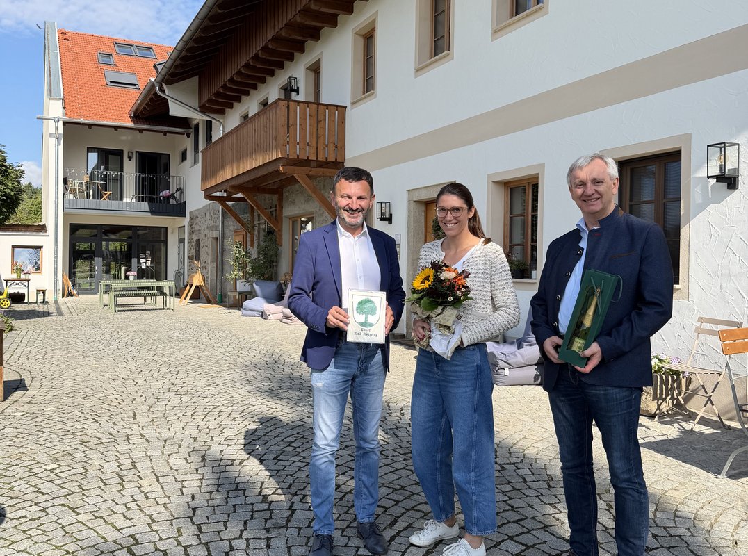 Gruppenbild mit Gratulation durch Bürgermeister Markus Hofmann zur Erweiterung des Lieblhofes von Anna Greisinger. Mit auf dem Bild ist Kurdirektor Sepp Barth. 
