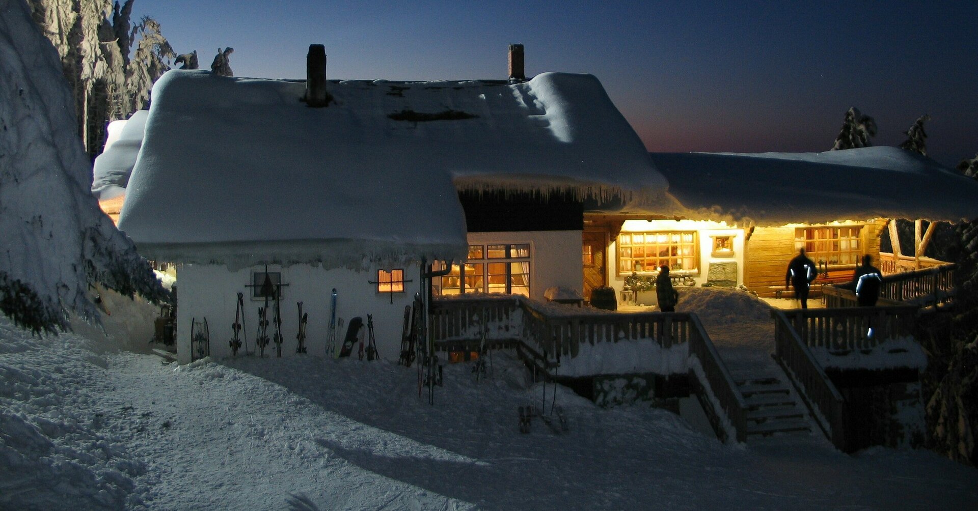 Schönblick Blick auf das verschneite Gebäude bei Nacht, die Räume innen sind erleuchtet