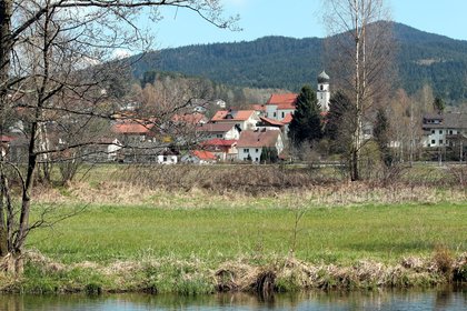 Blick über einen Fluss hin zur Kirche in Grafenwiesen