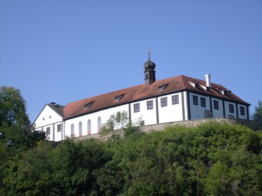 Blick auf das Schloss Altrandsberg, das auf einem Hügel hinter einer Mauer liegt