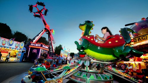 Blick auf buntes Treiben und Fahrgeschäft auf der Festwiese des Pfingstfestesin Bad Kötzting