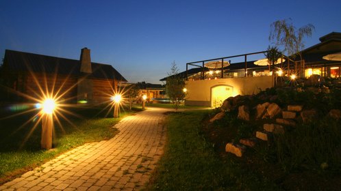 Blick auf den Außenbereich der Saunalandschaft am Abend, es ist alles beleuchtet